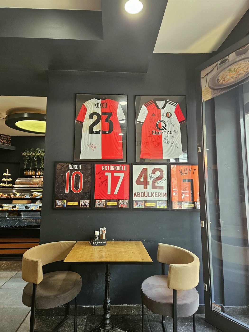 Gesigneerde Feyenoord-shirts van onder meer Kökcü aan de muur van Simit and Cheese.